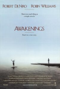 Poster for Awakenings featuring a vast, tranquil expanse of water under a pale blue sky. In the distance, one man stands on a dock while another balances triumphantly on the surface of the water with arms raised. The tagline reads, “There is no such thing as a simple miracle.” The names Robert De Niro and Robin Williams appear at the top, with the film noted as being based on a true story.
