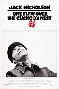 A stark black-and-white poster with a wire fence background shows Jack Nicholson gazing upward with a slight grin. The bold title “One Flew Over the Cuckoo’s Nest” appears above in stylized black lettering, with a red drawing of a lock hanging below the word “Cuckoo’s.”