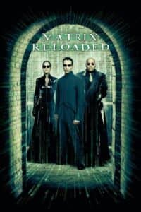 Poster for The Matrix Reloaded featuring the three main characters—Trinity (Carrie-Anne Moss), Neo (Keanu Reeves), and Morpheus (Laurence Fishburne)—standing in a stone tunnel framed by digital rain made of green code. All wear sleek black leather and dark sunglasses, standing in confident, formidable stances. The film title “The Matrix Reloaded” appears above them in glowing green, stylized type.