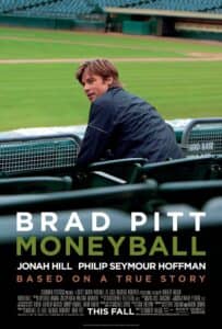 Brad Pitt sits in an empty baseball stadium, turning slightly to look back. The field stretches out behind him. Text reads: “Brad Pitt, Moneyball — Based on a True Story,” with Jonah Hill and Philip Seymour Hoffman also listed.
