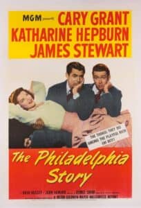 Classic film poster for The Philadelphia Story, featuring Katharine Hepburn reclining on Cary Grant’s lap, with James Stewart seated beside them, all looking amused. Bold yellow and red typography highlights the star-studded cast: Cary Grant, Katharine Hepburn, and James Stewart. A tagline reads: “The things they do among the playful rich — oh boy!”