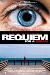 A film poster split into two striking visuals: the top half features a close-up of a wide, bloodshot blue eye, symbolizing intensity and altered perception. The bottom half shows a solitary woman in red standing on a pier, gazing out at a vast, empty ocean under a pale sky. The title “Requiem for a Dream” is bold and central, with “DREAM” highlighted in red. Above it reads “A Film by Darren Aronofsky,” and the cast includes Ellen Burstyn, Jared Leto, Jennifer Connelly, and Marlon Wayans.